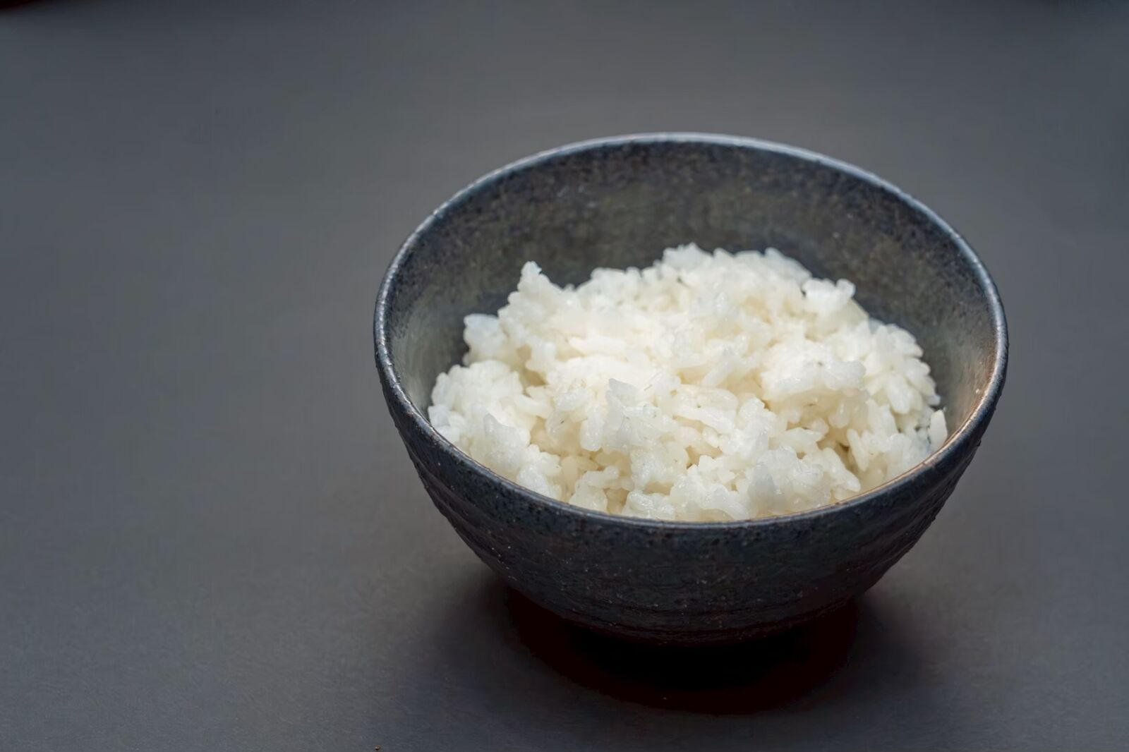 黒い茶碗に盛った祖生米のご飯